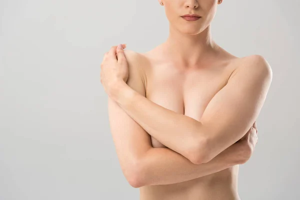Recortado vista de desnudo sexy mujer cubriendo pecho aislado en gris - foto de stock