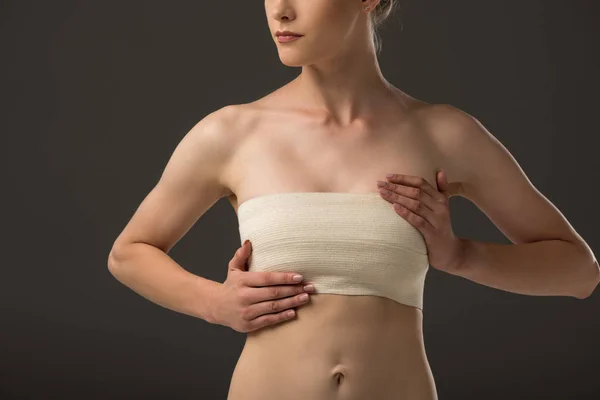 Partial view of woman with breast bandage isolated on grey — Stock Photo