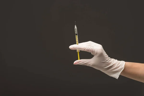 Vista recortada do médico em seringa luva de látex segurando isolado em cinza — Fotografia de Stock