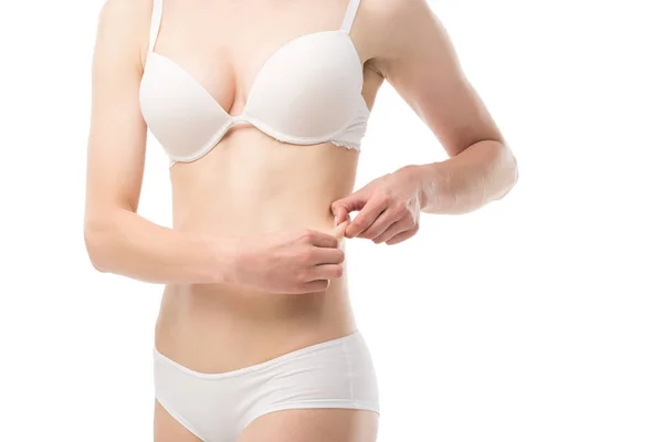 Частичный вид молодой женщины в нижнем белье, показывающий избыточный вес изолированы на белом — стоковое фото