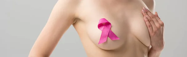 Panoramic shot of naked woman with pink ribbon isolated on grey — Stock Photo