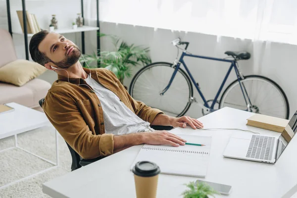 Thoughtful and good-looking man listening music and looking up — Stock Photo