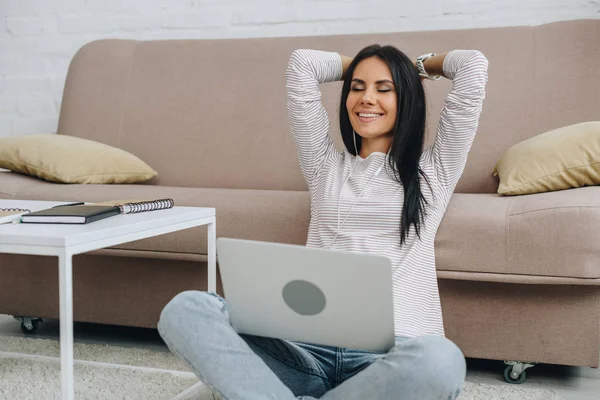 Bella donna con gli occhi chiusi sorridente e tenendo il computer portatile — Foto stock