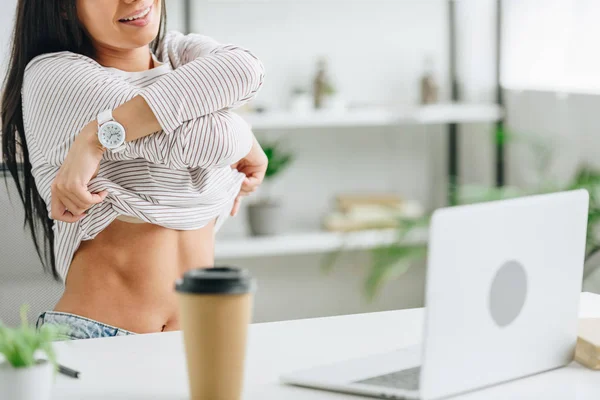Partial view of smiling woman showing her body and using laptop — Stock Photo