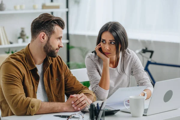 Schöne und brünette Frau mit Papier und Blick auf schönen Mann — Stockfoto