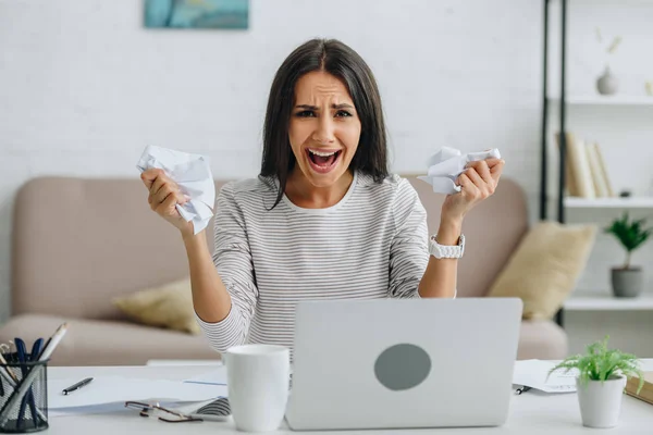 Screaming and attractive woman looking at camera and holding papers — Stock Photo