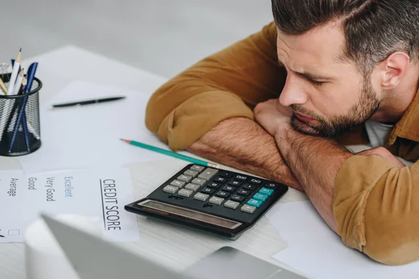 Selektiver Fokus eines traurigen Mannes mit geschlossenen Augen, der auf dem Tisch liegt — Stockfoto