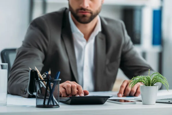 Vista recortada del hombre en desgaste formal utilizando la calculadora - foto de stock