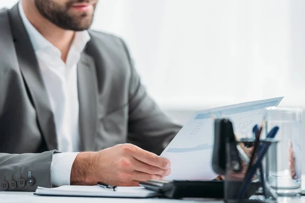 Cropped view of man in formal wear holding document in apartment — Stock Photo