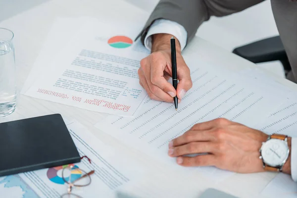 Vista recortada del hombre en la pluma de retención de desgaste formal y haciendo papeleo — Stock Photo