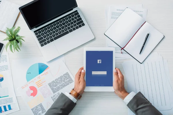 Top view of man holding digital tablet with facebook website — Stock Photo