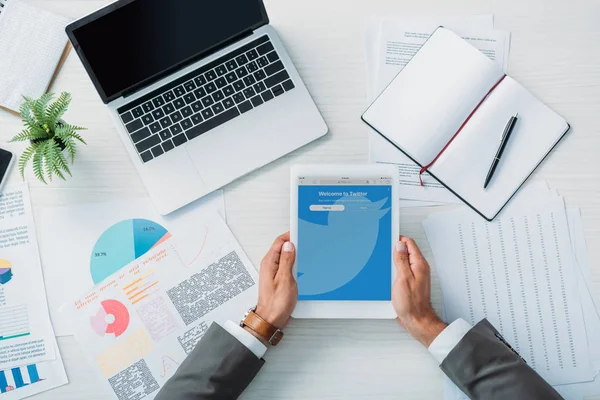 Top view of man holding digital tablet with twitter website — Stock Photo