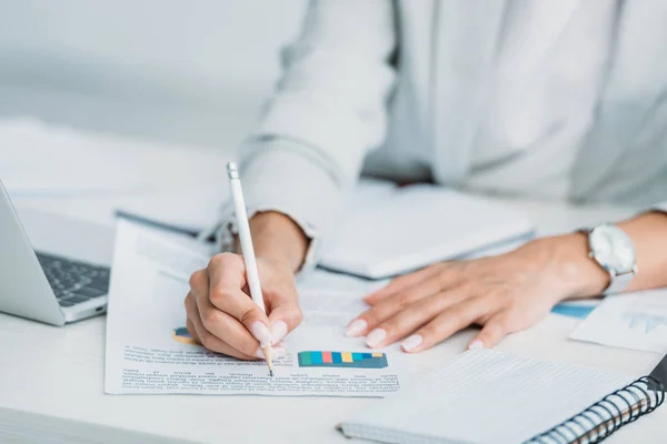 Vue recadrée de la femme en tenue formelle écriture sur document avec crayon — Photo de stock