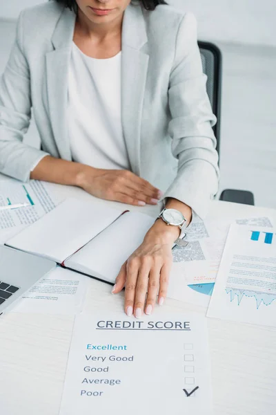 Vue recadrée de la femme en costume montrant pointage de crédit au bureau — Photo de stock