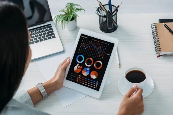 Cropped view of woman holding digital tablet with charts and graphs website on screen — Stock Photo