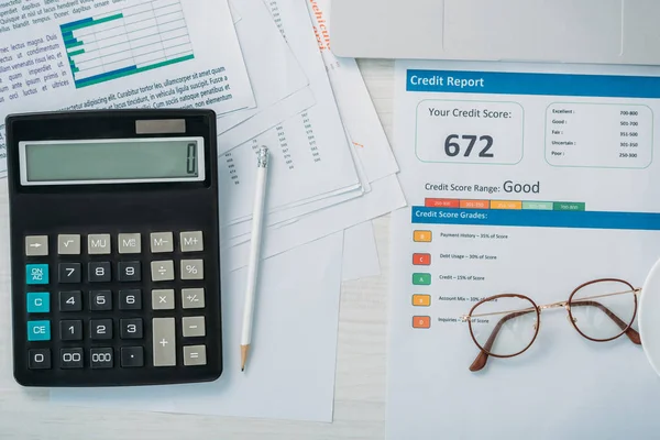 Vista superior do relatório de crédito, calculadora, óculos e lápis — Fotografia de Stock