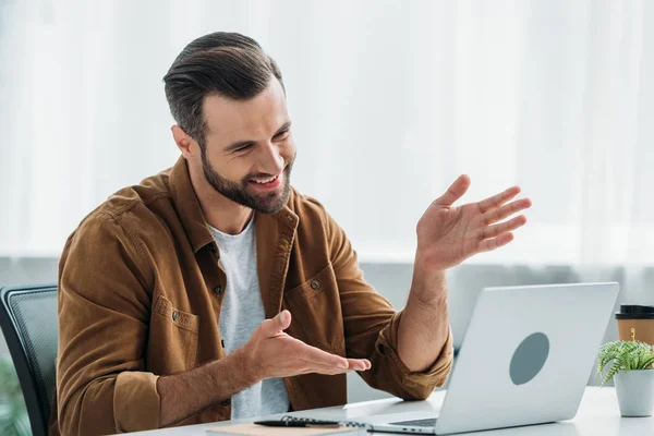 Uomo bello e felice sorridente e guardando lo schermo del computer portatile — Foto stock