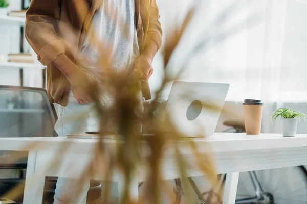 Selective focus of man dressing up in front of laptop — Stock Photo