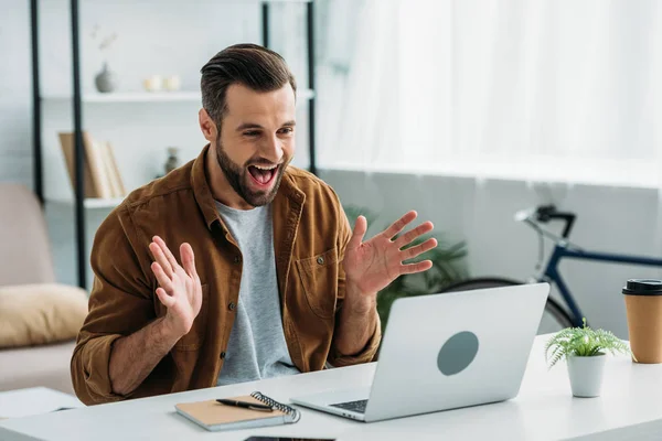 Uomo bello e felice sorridente e guardando lo schermo del computer portatile — Foto stock