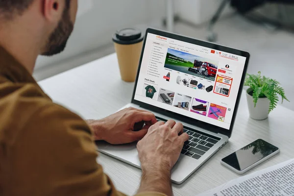 Cropped view of man using laptop with aliexpress website on screen — Stock Photo