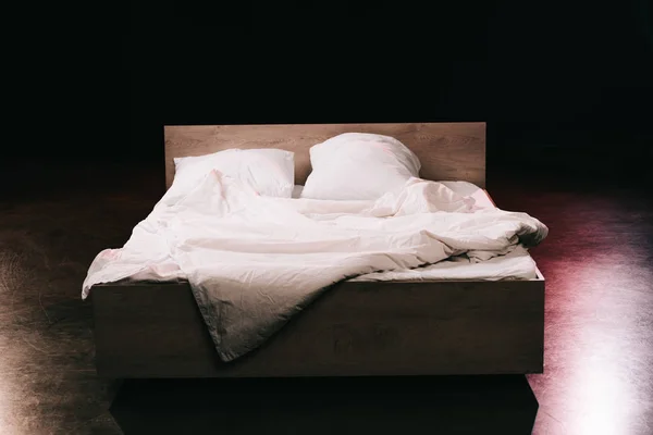 Travesseiros macios em lençóis brancos limpos no quarto em preto — Fotografia de Stock
