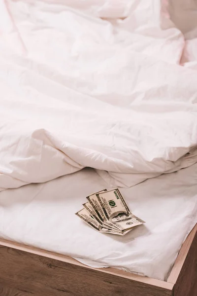 Foco seletivo das notas de dólar na roupa de cama branca — Fotografia de Stock