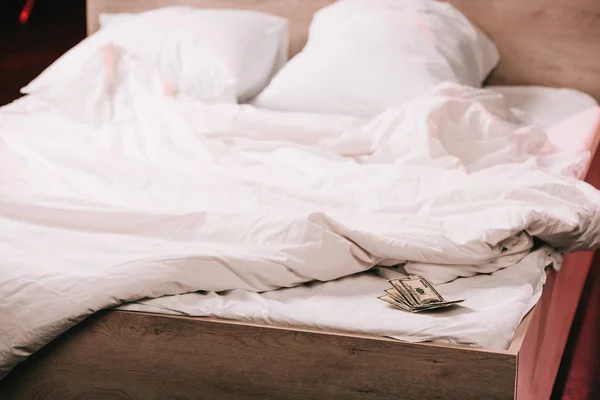 Selective focus of dollar banknotes on white clean bedding — Stock Photo