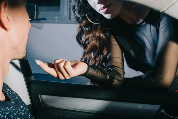 Vue recadrée de la femme pointant du doigt l'homme dans la voiture — Photo de stock