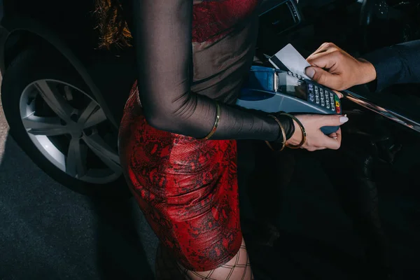 Обрізаний вид чоловіка, який платить під час проститутки, що тримає читача кредитних карток — стокове фото