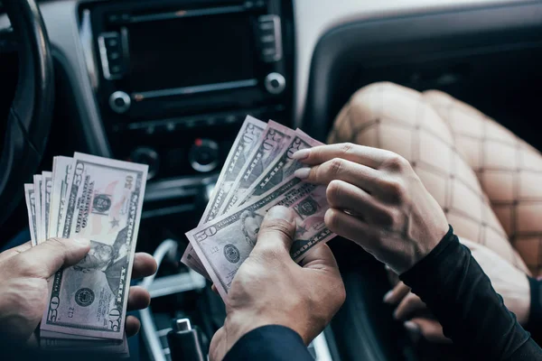 Vista cortada do cliente que paga notas de dólar à mulher no carro — Fotografia de Stock