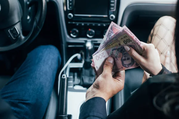 Visão cortada do cliente pagando em dinheiro para a mulher no carro — Fotografia de Stock