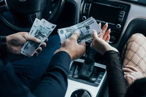 Cropped view of client paying cash to prostitute in car — Stock Photo
