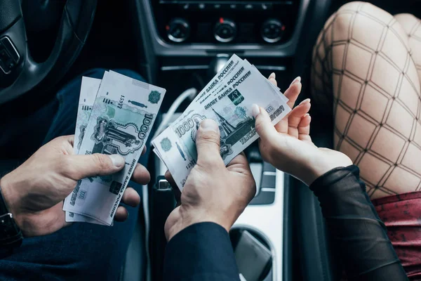 Cropped view of client paying money to prostitute in car — Stock Photo