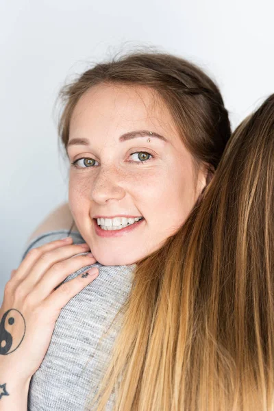 Recortado vista de dos lesbianas abrazando en casa - foto de stock