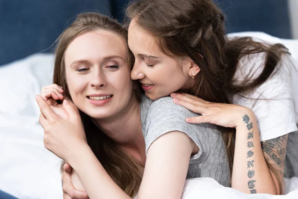 Duas lésbicas felizes abraçando na cama de manhã — Fotografia de Stock