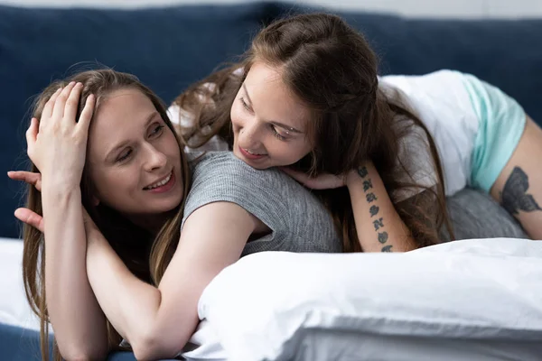 Duas lésbicas felizes abraçando na cama de manhã — Fotografia de Stock