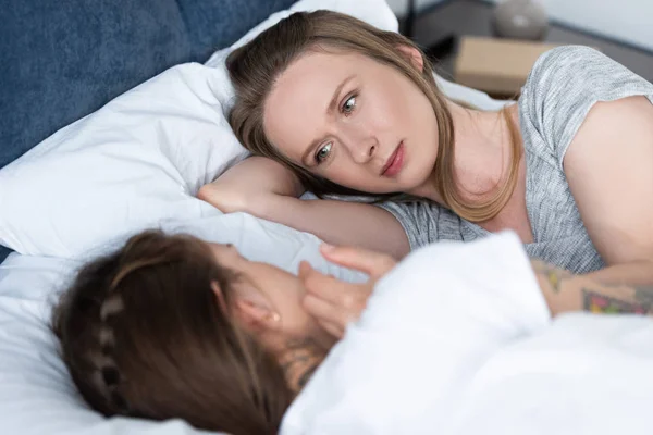 Selektiver Fokus zweier Lesben, die einander im Bett anschauen — Stockfoto