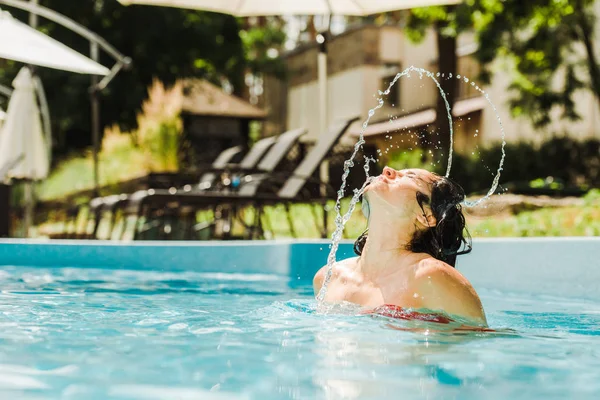 Foyer sélectif de femme attrayante avec les yeux fermés dans la piscine en plein air — Photo de stock