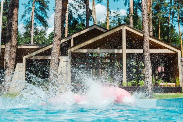 Splash in der Nähe von aufblasbaren Ringen im Schwimmbad mit sauberem, blauem Wasser — Stockfoto