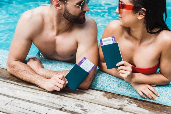 Homme et femme portant des lunettes de soleil munies de passeports avec billets d'avion — Photo de stock