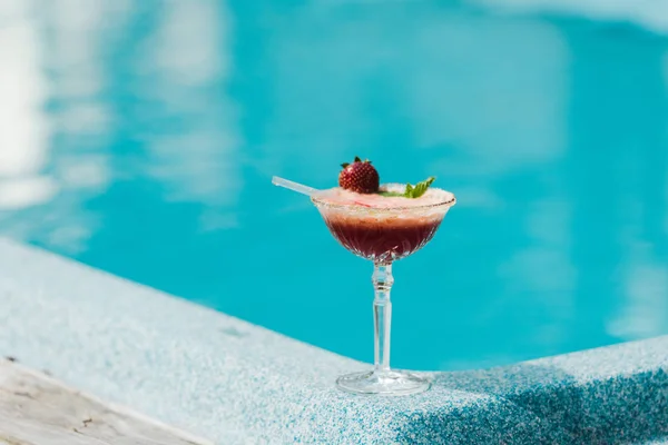 Selektiver Fokus des Cocktailglases mit Alkoholgetränk in Schwimmbadnähe — Stockfoto