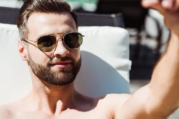 Вибірковий фокус красивого без сорочки чоловіка в сонцезахисних окулярах — стокове фото