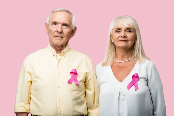 Casal aposentado com cabelos grisalhos e fitas como consciência bullying isolado em rosa — Fotografia de Stock