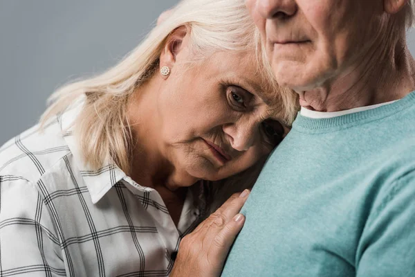 Vue recadrée retraité homme près bouleversé senior femme isolé sur gris — Photo de stock