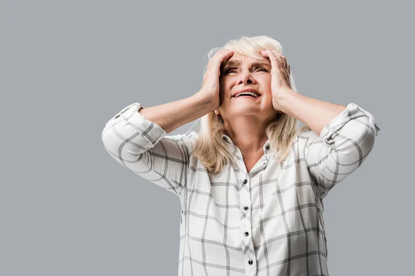 Расстроен пенсионерка с седыми волосами касаясь головы изолированы на седой — стоковое фото