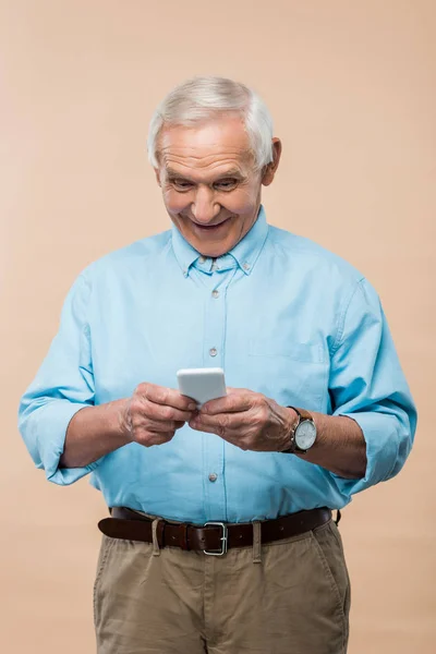 Glücklicher Rentner mit grauen Haaren, Smartphone isoliert auf beige — Stockfoto
