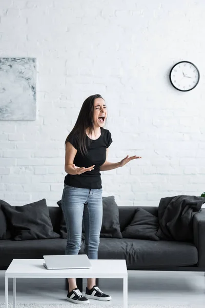 Jovem infeliz gritando e gesticulando enquanto sofre de depressão em casa — Fotografia de Stock