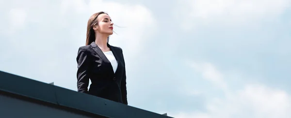 Belle femme d'affaires confiante debout sur le toit, souriant et détournant les yeux — Photo de stock