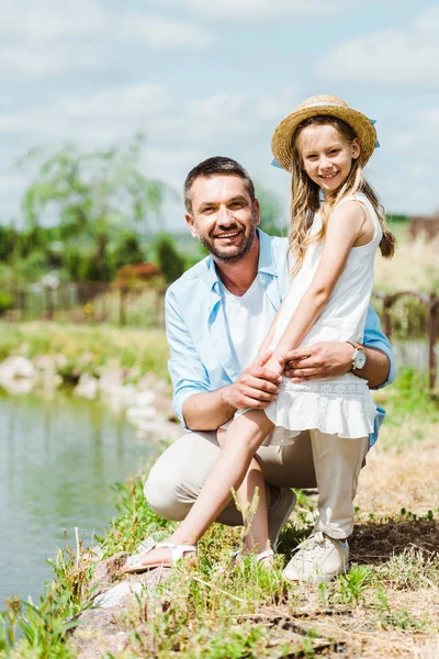 Вибірковий фокус милої дитини, що стоїть біля щасливого батька і озера — стокове фото