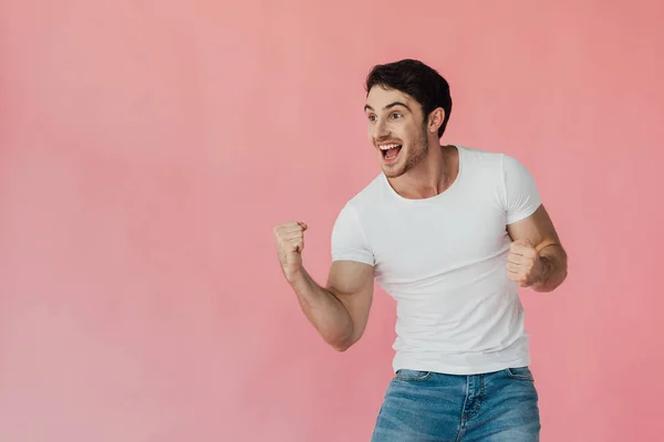 Excité homme en t-shirt blanc montrant geste oui isolé sur rose — Photo de stock